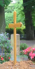 Holzkreuz an frischem Grab